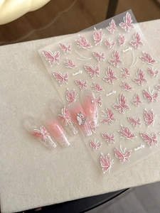 Macro detail of 3D embossed pink butterfly nail art stickers with elegant pearl accents