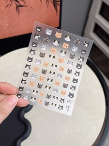 Detail view of assorted cartoon cat nail stickers on a translucent sheet with item YT4568