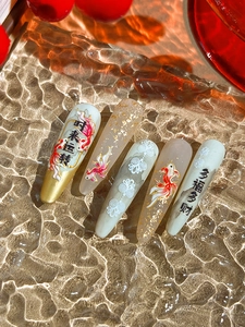 Macro detail of red koi fish and golden foil nail stickers with traditional Chinese patterns