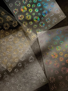 Detailed macro view of laser gold firework nail art stickers with metallic glitter finish