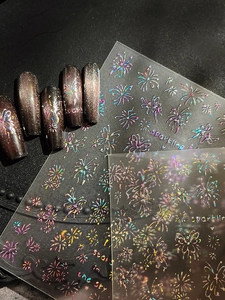 Macro detail of laser holographic butterfly and firework nail stickers on glitter tips