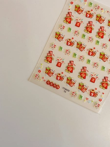 Detail of Lunar New Year nail art stickers featuring red envelopes and gold firecrackers