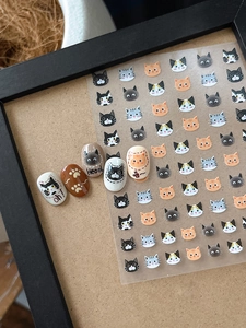 Detail of cute cartoon cat nail art stickers featuring various kitten designs on matte nails