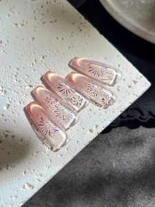 Macro detail of pink cat-eye press-on nails with laser fireworks on white stone