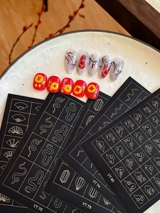 Detail of Chinese New Year nail art stickers with gold lanterns, snakes, and lucky motifs