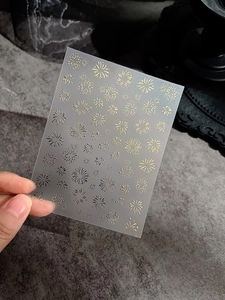 Macro detail of laser gold fireworks nail art stickers with holographic glitter effects