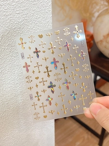Macro detail of YT4376 holographic gold nail stickers with cross and heart patterns