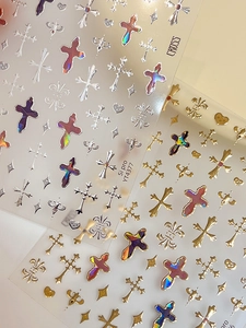 Detail of holographic cross and star nail art stickers with metallic finish effects