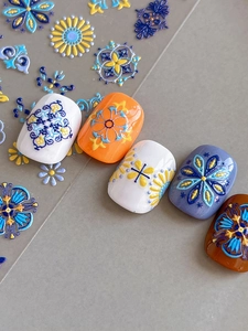 Macro detail of 3D embossed bohemian nail art stickers with vintage floral patterns