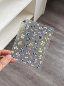 Close-up of bohemian floral and geometric nail stickers with dark blue and green patterns