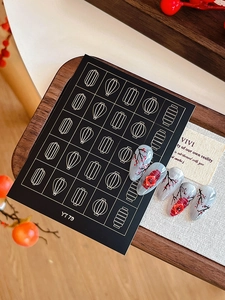 Macro detail of Chinese New Year nail stickers featuring red lanterns and plum blossoms