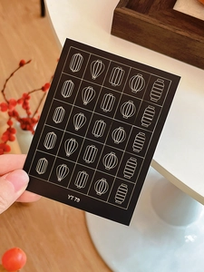 Detailed view of YT79 nail stickers featuring golden lantern patterns on black base