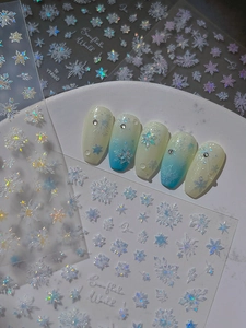 Detailed macro view of laser iridescent snowflake nail stickers with cold blue holographic finish