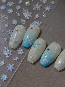 Macro detail of iridescent snowflake nail stickers with holographic laser effects and rhinestones
