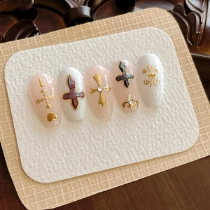 Luxurious handmade press-on nails featuring gold crosses, fleur-de-lis, and sparkling rhinestones