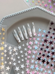 Detailed view of gold and silver star nail stickers with long coffin press-on nails