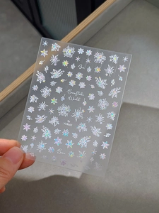 Detailed view of laser iridescent snowflake nail art stickers with various patterns