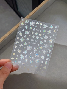 Macro detail of laser iridescent snowflake nail art stickers with self-adhesive backing