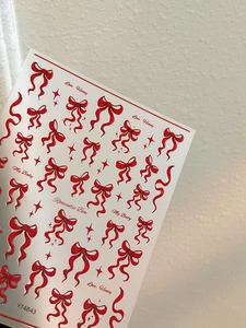 Detailed view of red bow and star nail art stickers with Love Honey text elements