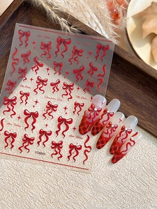Detail of red bow nail art stickers with romantic ribbons and stars for DIY manicure