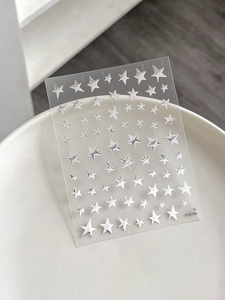 Close-up of shiny silver star nail art stickers with metallic reflective finish on base