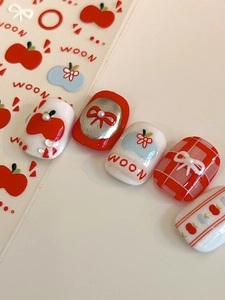 Detail of 3D embossed apple and bow nail stickers with pearls and rhinestones