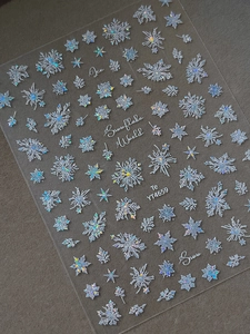 Macro detail of laser iridescent snowflake nail stickers with holographic ice crystal motifs