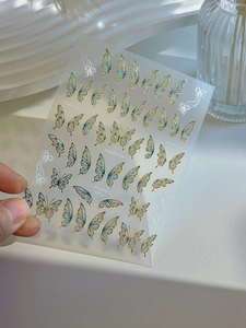 Detailed view of blue gradient butterfly nail stickers with gold edges and YT4900 serial number
