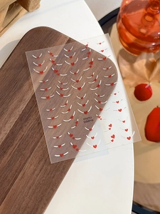 Detail of YT4751 nail stickers featuring red heart patterns and elegant white curves