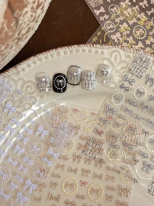 Detail of embossed bow and pearl patterns on 3D adhesive nail art stickers