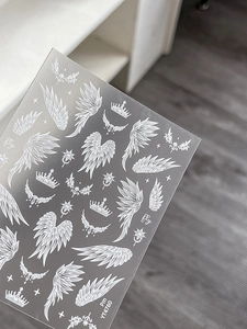 Detail of white nail art stickers with angel wings, crowns and star motifs YT4760