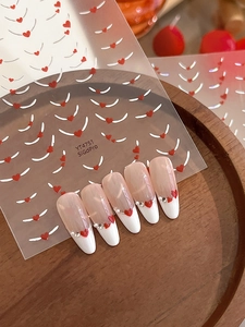 Detail of French heart nail stickers with rhinestones and laser jelly finish on wood