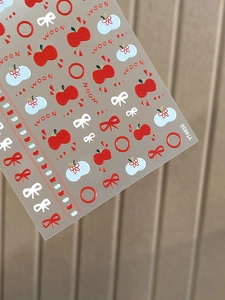 Detail view showing 3D embossed apple and bow nail art stickers with textured surface