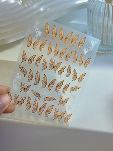 Detail of Butterfly Dream nail stickers with champagne gold foil wings and ribbon patterns