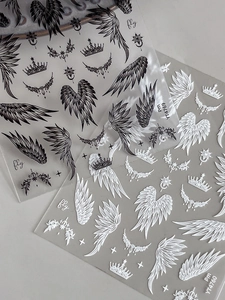 Detail of wing and crown nail art stickers with black and white gradient patterns
