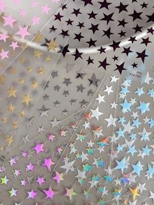 Detailed close-up of multi-color pentagram star nail art stickers with metallic finish