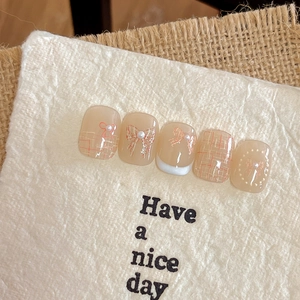 Japanese style nude bow nail stickers with pearls and orange plaid patterns on white paper