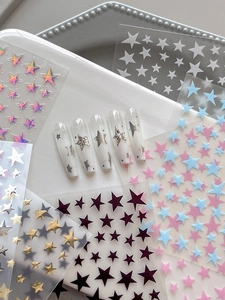 Macro detail of holographic star nail art stickers with 3D rhinestones on long press-on nails