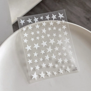 Star nail art stickers with gold stamping stars on a white ceramic display tray