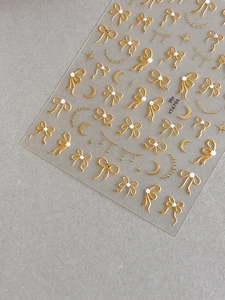 Détails macro d'autocollants 5D dorés pour ongles avec nœuds, lunes et étoiles