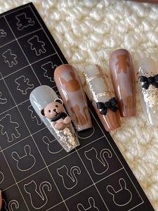 Detail of long coffin press-on nails featuring 3D brown bear and cat silhouette designs