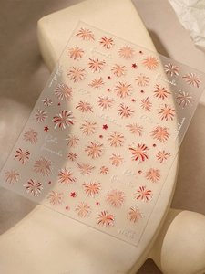 Detail of laser gold and red firework nail stickers with star patterns and adhesive backing