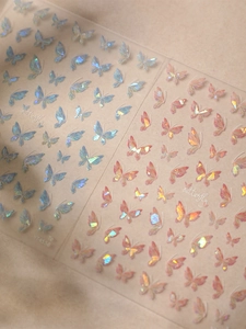 Macro view of holographic butterfly nail stickers in blue and pink tones YT4558