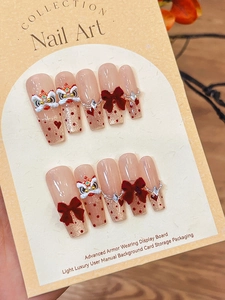 Macro detail of handmade press-on nails with 3D lion dance motif and red bows