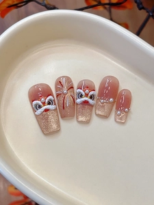 Detail of 3D lion dance press-on nails with gold glitter, pearls and embossed patterns