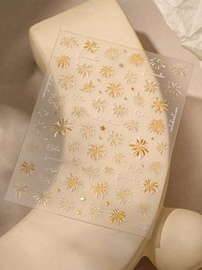 Detailed view of holographic laser firework nail stickers with gold and silver patterns