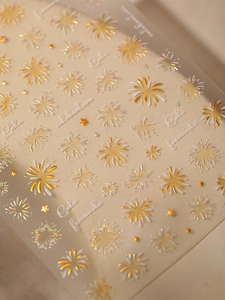 Macro shot of 3D embossed fireworks and star nail stickers with golden celebration text