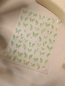 Macro view of 3D aurora green butterfly nail stickers with holographic relief effect