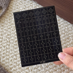 Gothic gold cross and star nail art stickers on black background with adhesive backing