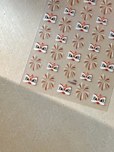 Detail of 3D embossed Chinese lion and fireworks nail decals with gold foil accents